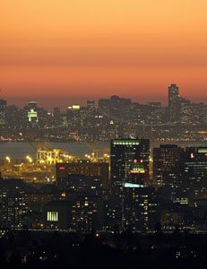 Harbor lights and highrises under a glowing sunset