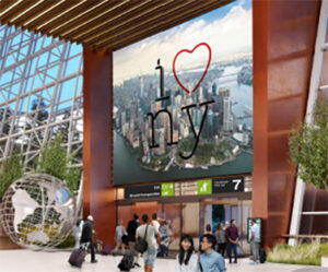 Indoor transit hub with 'I love NY' billboard