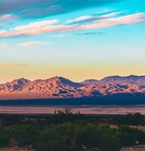 Sunset over colorful desert mountains and plain