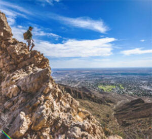 Hiker on rocky ridge overlooking valley