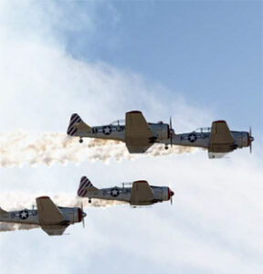 Three vintage military planes flying formation
