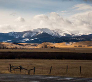Rolling prairie with snow-capped mountains backdrop