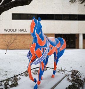 Painted horse sculpture in snow outside Woolf Hall