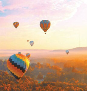 Colorful hot air balloons over autumn valley