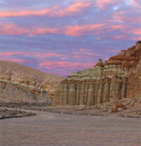 Eroded canyon columns beneath pink sky