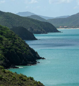 Turquoise bay with layered green coastal headlands