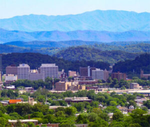 Small city nestled before layered blue mountain ridges
