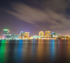 Night skyline reflected across calm harbor water