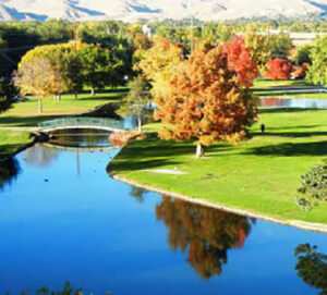Reflective park pond with arched footbridge