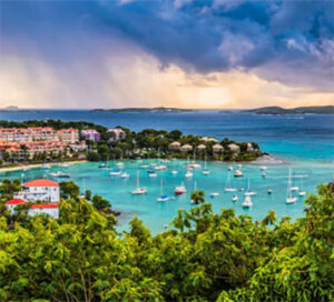 Turquoise bay with anchored sailboats and resort